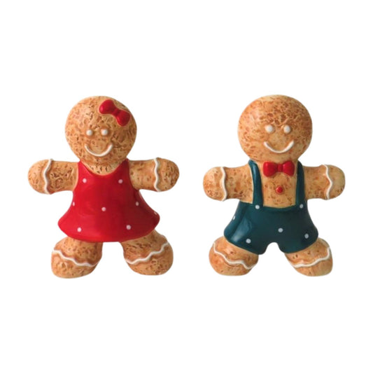 Two gingerbread figurines, one in a red dress and the other in a blue outfit 