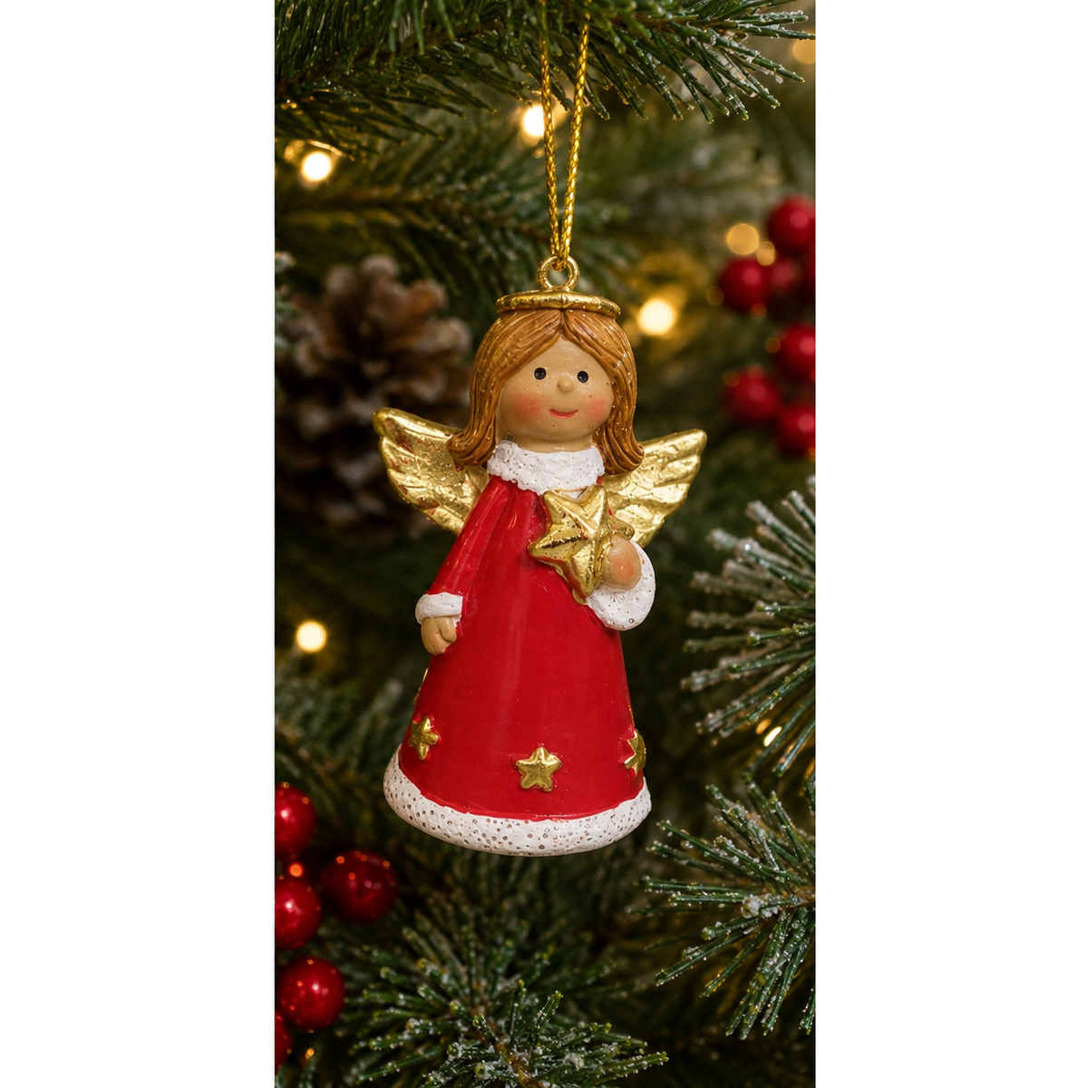 A Christmas angel ornament hanging on a decorated Christmas tree. The ornament features a smiling angel with brown hair, a gold halo and wings, a red dress with white trim, and a gold star.